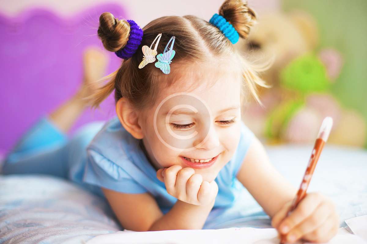 Happy little girl painting in her room