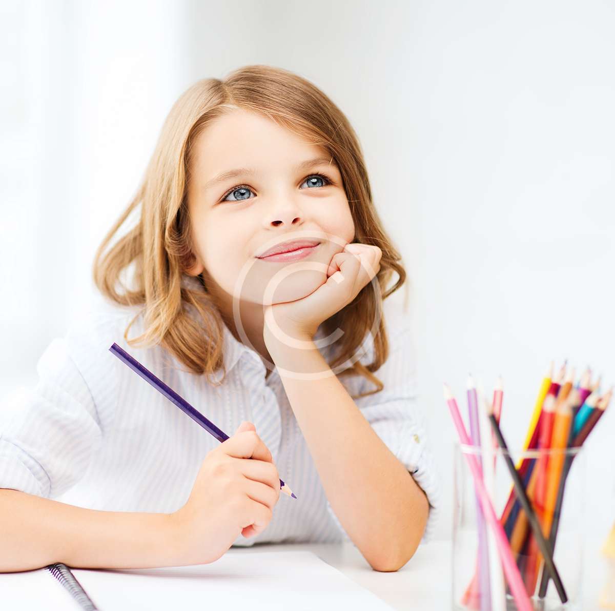 girl drawing with pencils at school